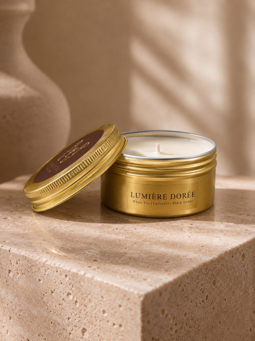 LUMIÈRE DORÉE Golden Tin Candle in a sleek container, perfect for travel, with a warm, inviting glow.