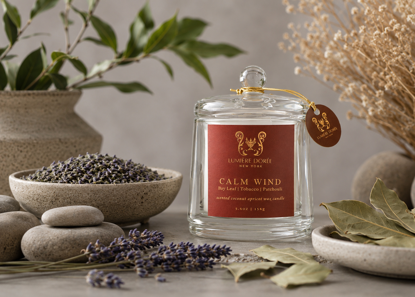 Lumière Dorée Signature Cloche Candle in a glass container with bay leaves and tobacco scent, elegant home fragrance.